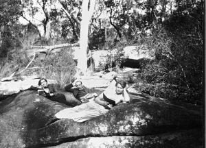 black and white photo of Man two women lying on a rock (from Museum Victoria)